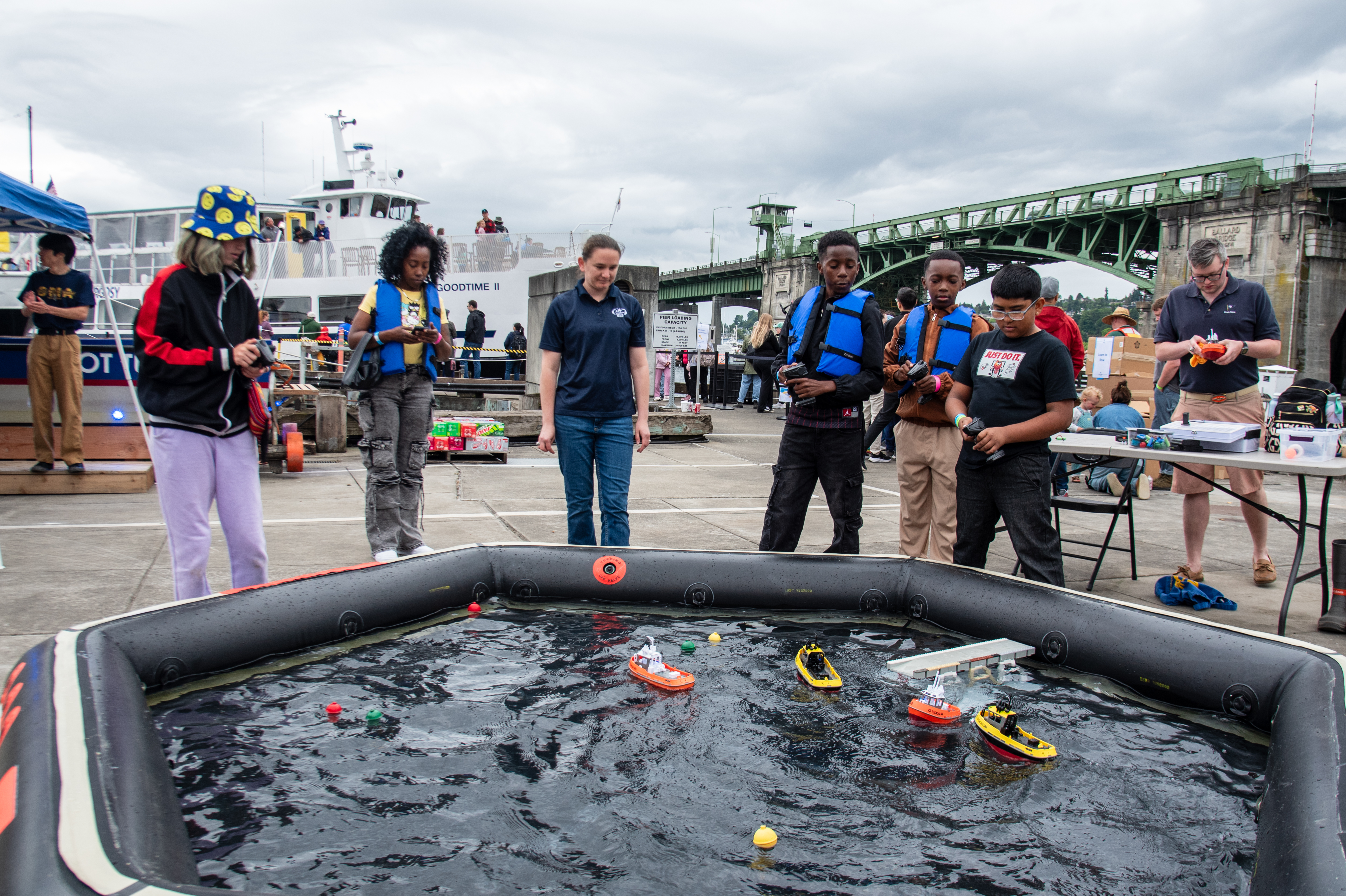 Community Day attendees steering RC tug boats